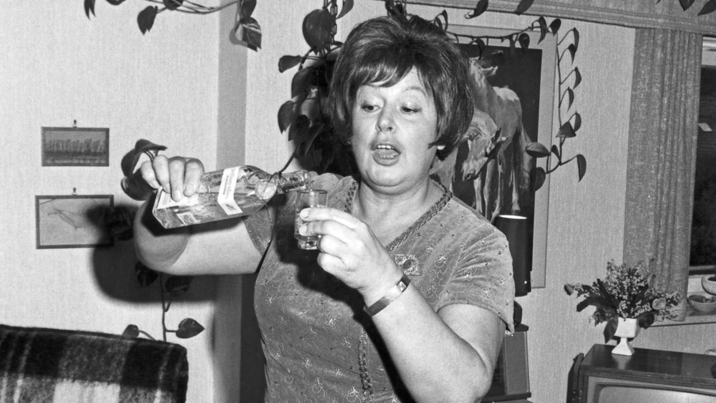 Eine Frau trinkt einen klaren Schnaps