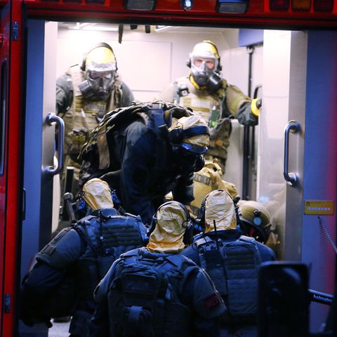 Polizisten in Schutzanzügen vor dem Kölner Hochaus, in dem sie Rizin fanden