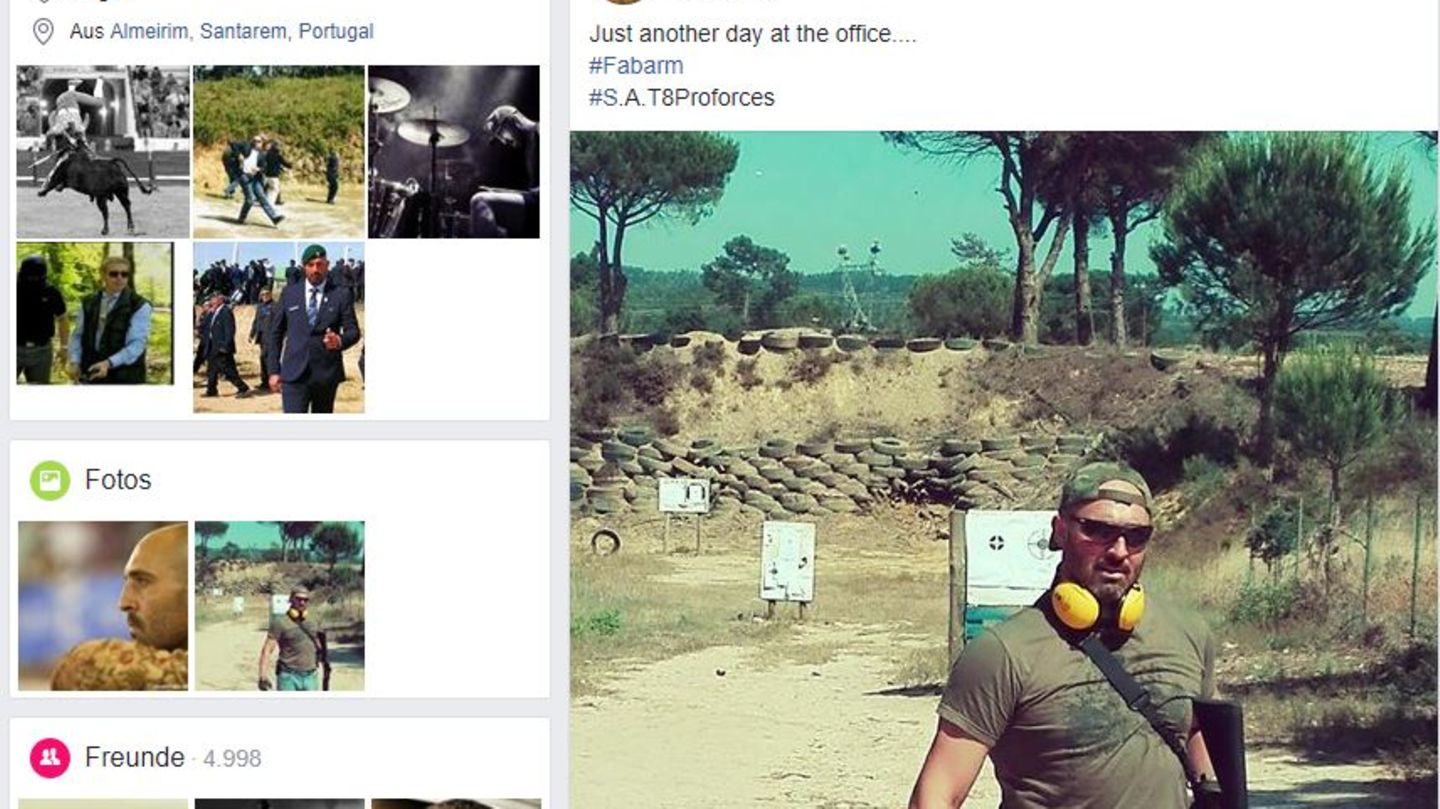 Ein muskulöser Mann mit Sonnenbrille und Ohrschützern posiert mit einem schweren Gewehr auf einem Schießplatz