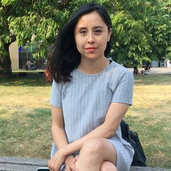 Junge Frau sitzt im Park.