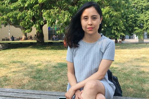 Junge Frau sitzt im Park.
