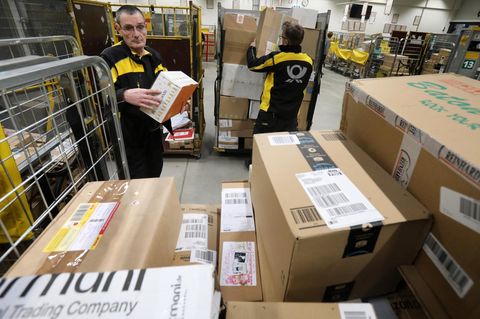 DHL-Fahrer mit vielen Paketen