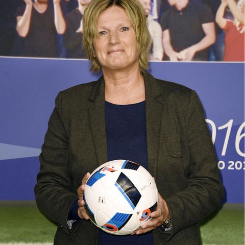 Claudia Neumann hält einen Fußball in der Hand