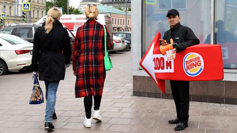 Ein lebender Werbetraeger von Burger King weist den Passanten in der Moskauer Innenstadt den Weg