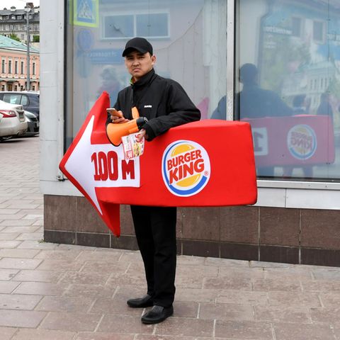 Ein lebender Werbetraeger von Burger King weist den Passanten in der Moskauer Innenstadt den Weg