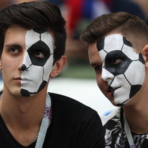 Fußballfans, die sich ein Ballmuster ins Gesicht geschminkt haben