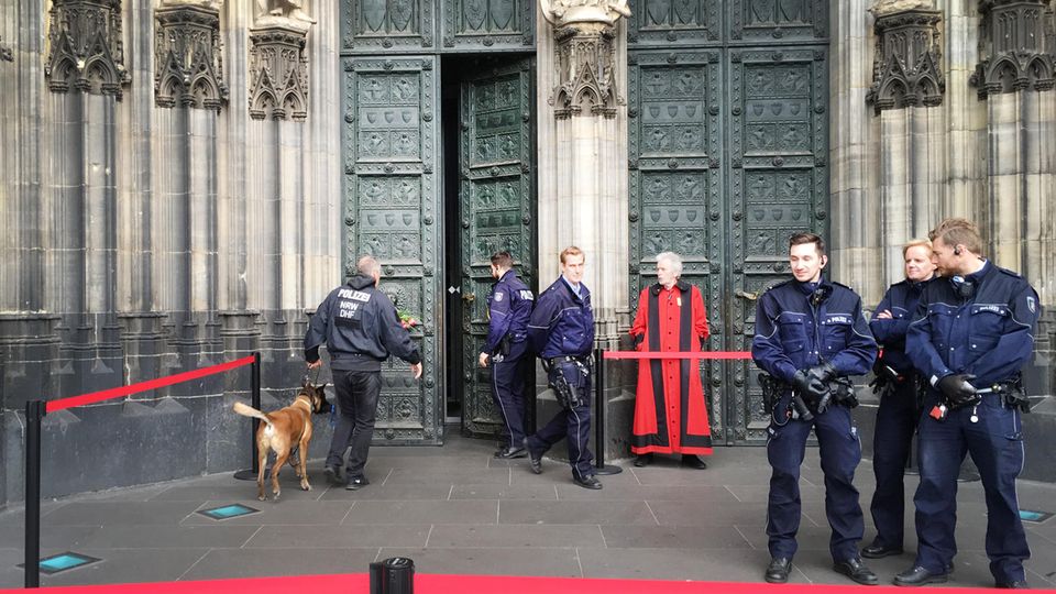 Ein Polizist geht mit einem Spürhund in den gesperrten Dom