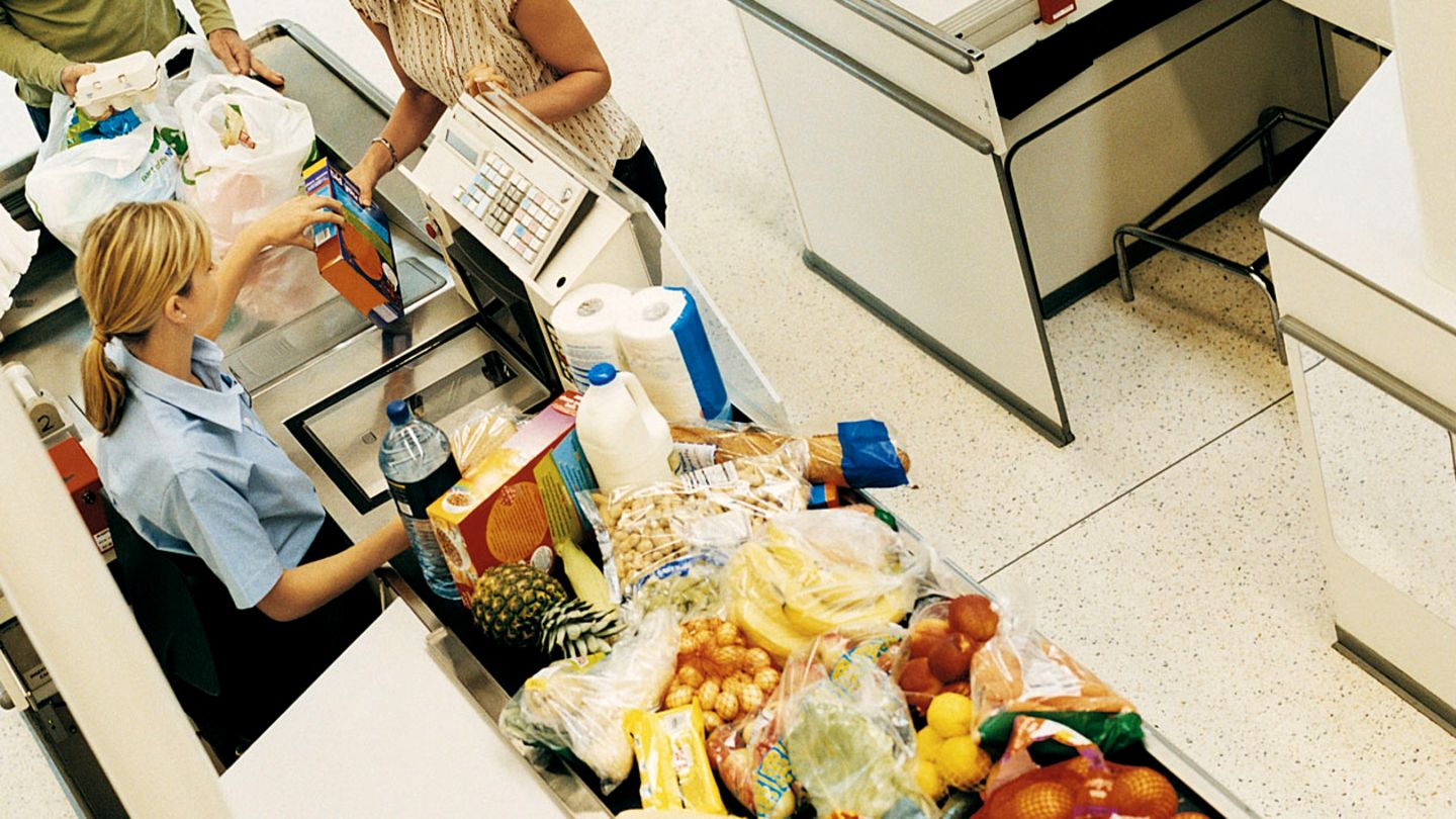 Kassiererin sitzt an der Kasse im Supermarkt