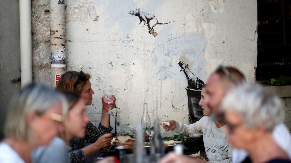 Banksy in Paris In einem Pariser Restaurant fliegt eine Banksy-Ratte auf einem Sektkorken über die Köpfe der Menschen hinweg