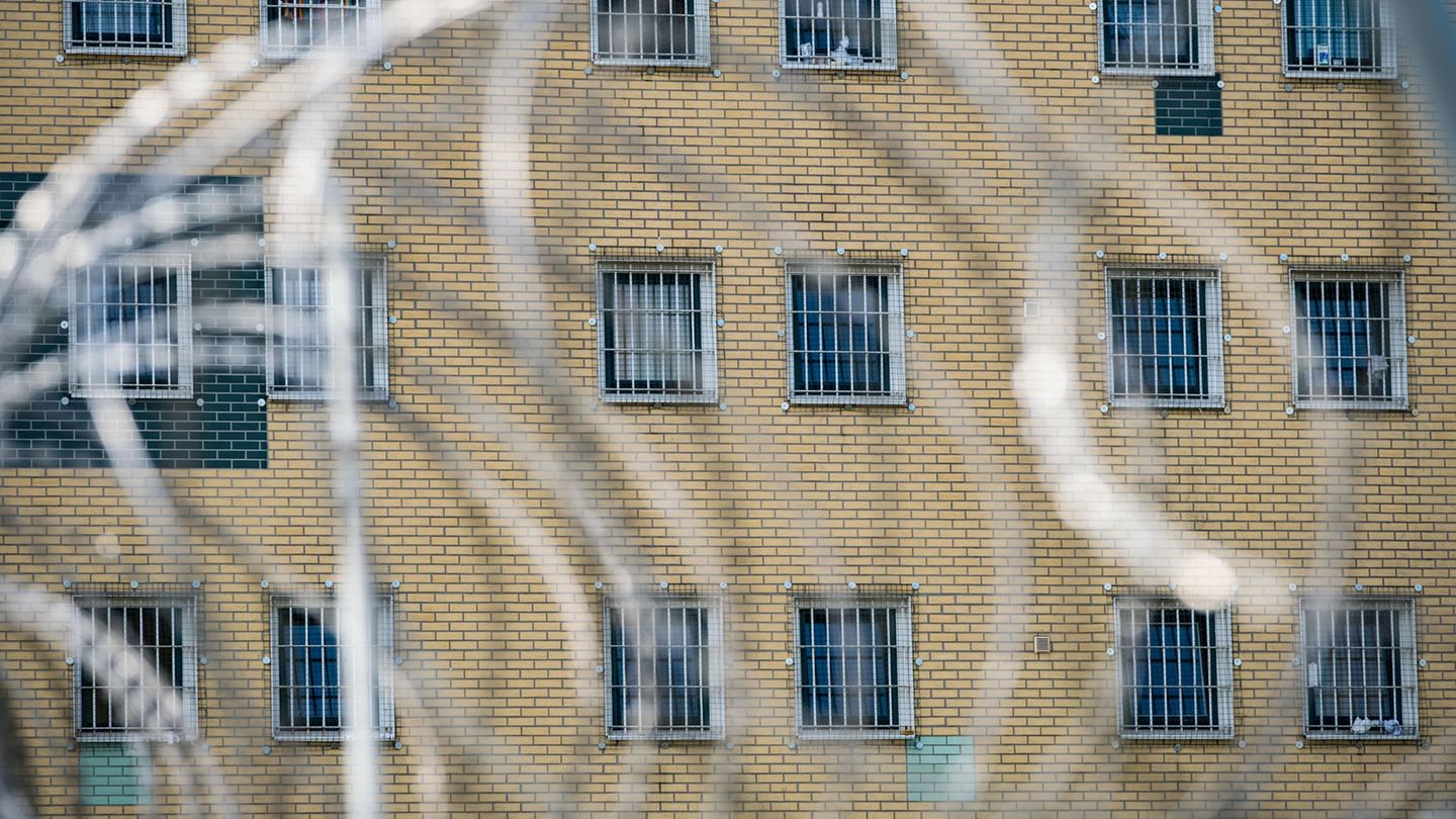 Fenster eine JVA im Hintergrund, Stacheldraht im Vordergrund