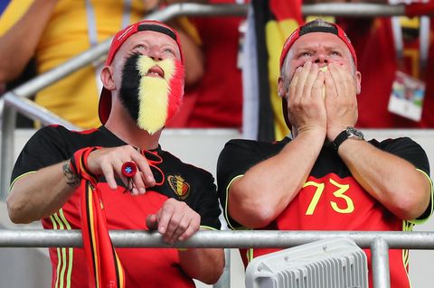 Zwei Fans in belgischen Trikots und mit falschen Bärten in Nationalfarben schauen gespannt der belgischen Elf zu