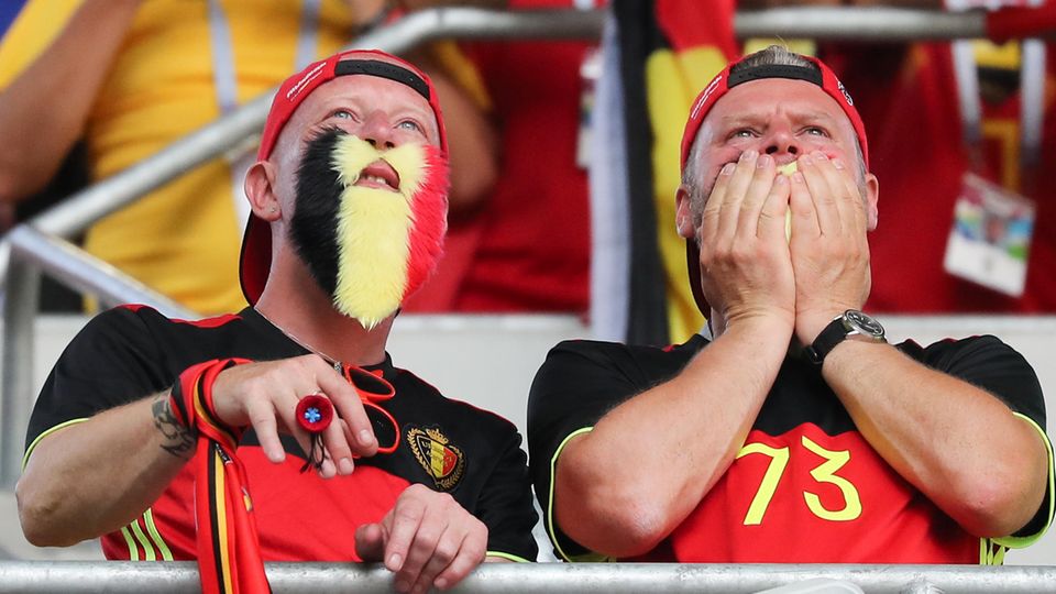 Zwei Fans in belgischen Trikots und mit falschen Bärten in Nationalfarben schauen gespannt der belgischen Elf zu