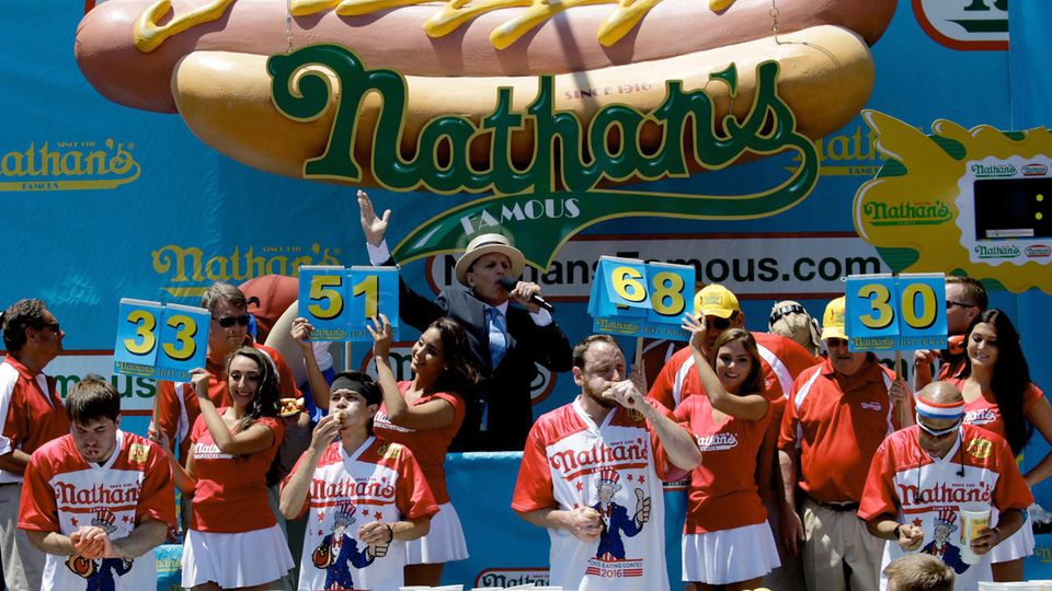 Joey Chestnut (Mitte, rechts) und Matt Stonie (Mitte, links) beim Hotdog-Wettessen. Der Kalifornier Chestnut gewann damals mit 70 Würstchenbroten und machte damit seinem Ruf als Champion alle Ehre.