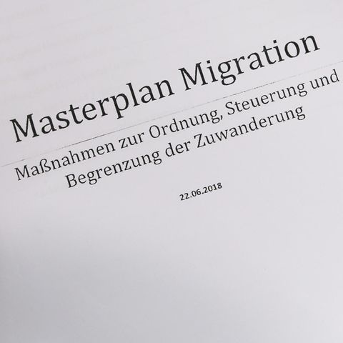 Eine linke Frauenhand hält einen Ausdruck des "Masterplans Migration" der CSU