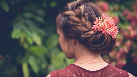 Mädchen von hinten mit Blumen im Haar