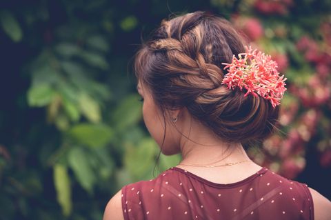 Mädchen von hinten mit Blumen im Haar