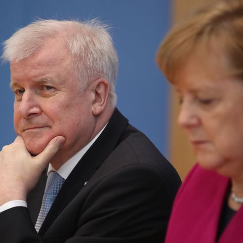 Horst Seehofer schaut skeptisch und stützt sich auf sein Kinn, Angela Merkel schaut auf den Tisch vor sich