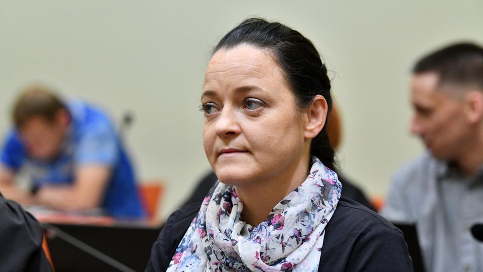 Mit dunkelblauem Pullover und einem geblümten Seidenschal sitzt Beate Zschäpe im NSU-Prozess auf der Anklagebank