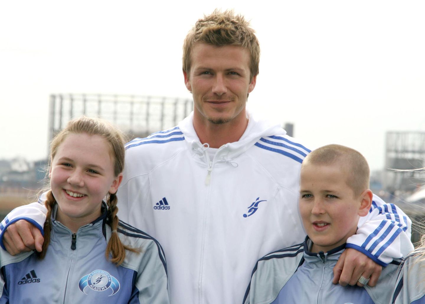 David Beckham (M.) gemeinsam mit Katie Goodland und Harry Kane im März 2005