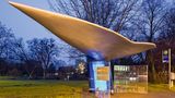 Flosse … ähem … Fluke hoch!  So, jetzt heißt es mal die Fantasie anschmeißen, wir sind ja nicht zum Spaß hier. Hier, das ist einmal mehr Hannover, "The World Capital of kreative Bushaltestellen", wie es seit dem Bus-Stop-Kunstprojekt von 1994 so schön heißt.  Ach ja, die Fantasie: Aus dieser Perspektive sieht der Entwurf von Heike Mühlhaus am Maschsee aus, als würde man von links unten auf die Schwanzflosse – die Fluke – eines Wals schauen. Gut, es könnte auch das silberne Raumschiff des Königshauses von Naboo aus "Star Wars" sein. Aber da kann es ja jeder mit der Fantasie halten, wie er will.