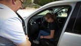 Instruktor Sascha Herweg zeigt Anna beim Land Rover Kinderfahrtraining, wie man den Sitz optimal einstellt