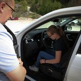 Instruktor Sascha Herweg zeigt Anna beim Land Rover Kinderfahrtraining, wie man den Sitz optimal einstellt