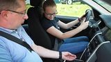 Instruktor Sascha Herweg erklärt Anna beim Land Rover Kinderfahrtraining, wie eine Schaltung funktioniert