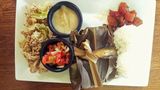 Stopp 3: Knolle mit Tradition  Polynesier brachten einst Taro nach Hawaii, eine Gewächs mit stärkehaltigen Knollen. Der Legende nach wuchs die Pflanze auf dem Grab eines totgeborenen Kindes der Papahānaumoku und des Wakea: Mutter Erde und Vater des Himmels. Aus Taro wird noch heute Poi hergestellt, ein violetter Brei, der reich an Kohlehydraten ist. Eine besonders leckere Verwendung findet die Zutat in den pikanten Chips von Dale Nagamine, Besitzer der Taro Ko Farm (3940 Hanapepe Rd, Hanapepe). Im Bild ein typisches hawaiianisches Gericht mit Kalua Pig, Lau Lau, Lomi Lomi Salmon, Poke und Poi.