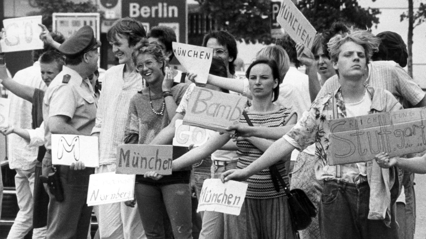 Reisen in den frühen 80er Jahren: Tramper stehen am Kontrollpunkt Dreilinden in Berlin und warten auf eine Mitfahrgelegenheit für die Transitstrecke durch die DDR nach Westdeutschland.
