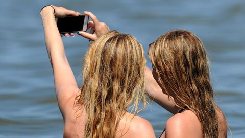 Zwei jungen Frauen machen in der Nordsee im Wasser ein Selfie.