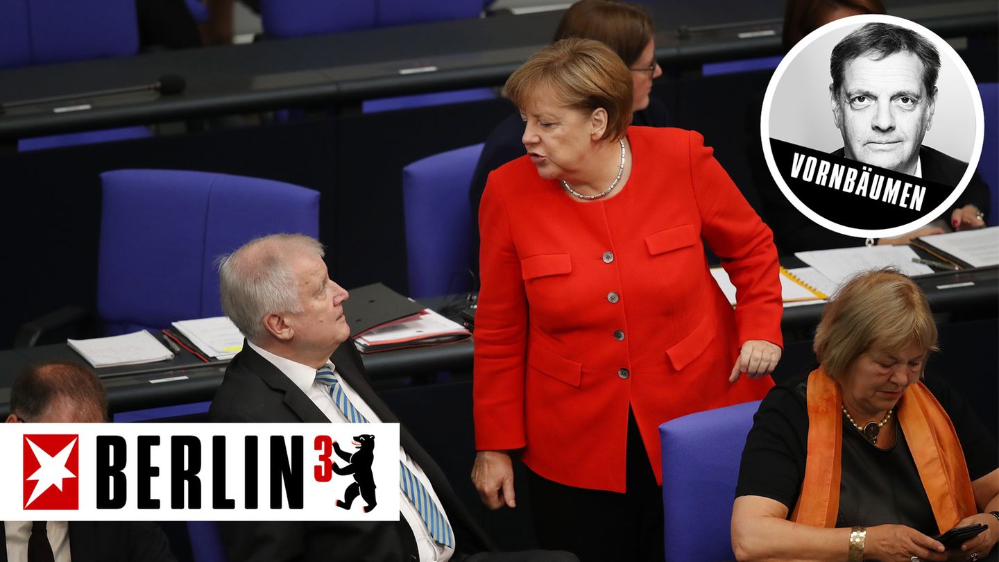Im Bundestag steht Angela Merkel im roten Blazer vor Horst Seehofer, der auf seinem blauen Stuhl sitzt