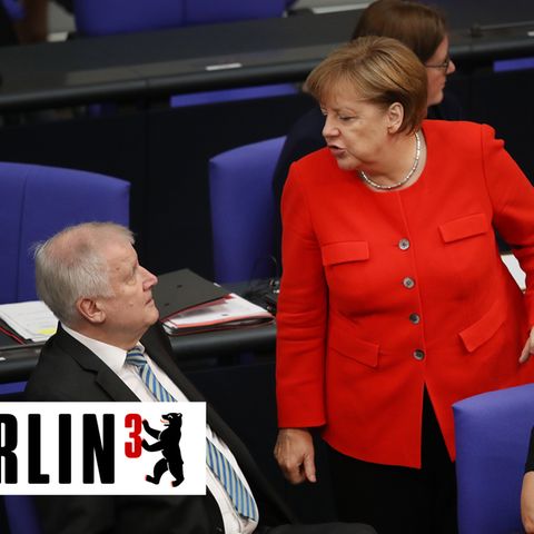 Im Bundestag steht Angela Merkel im roten Blazer vor Horst Seehofer, der auf seinem blauen Stuhl sitzt