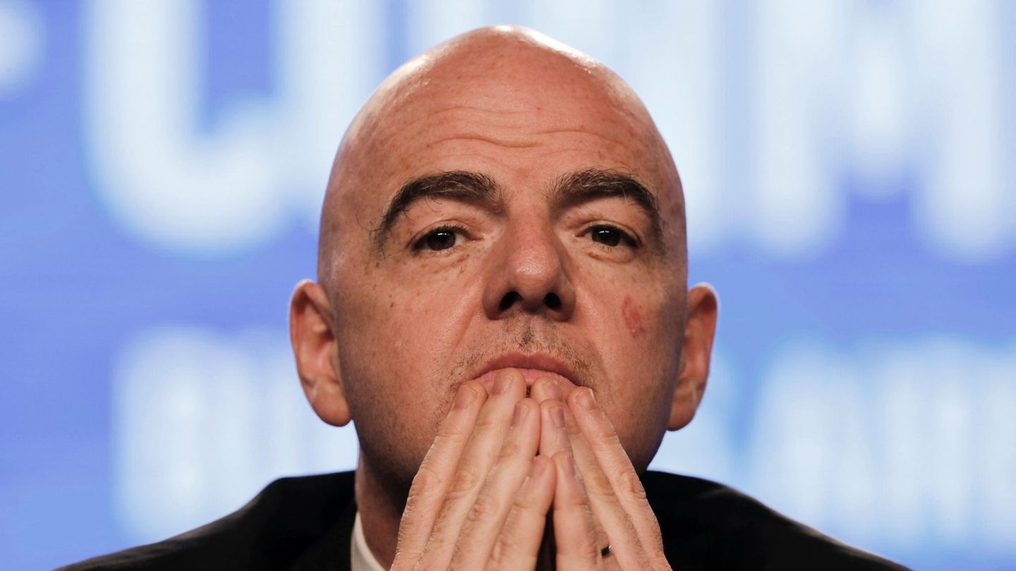 Fifa-Präsident Gianni Infantino sitzt auf einem Podium und hält sich die Finger beider Hände vor sein Kinn