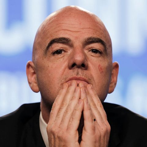 Fifa-Präsident Gianni Infantino sitzt auf einem Podium und hält sich die Finger beider Hände vor sein Kinn