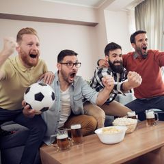 Freunde jubeln beim Fußball gucken