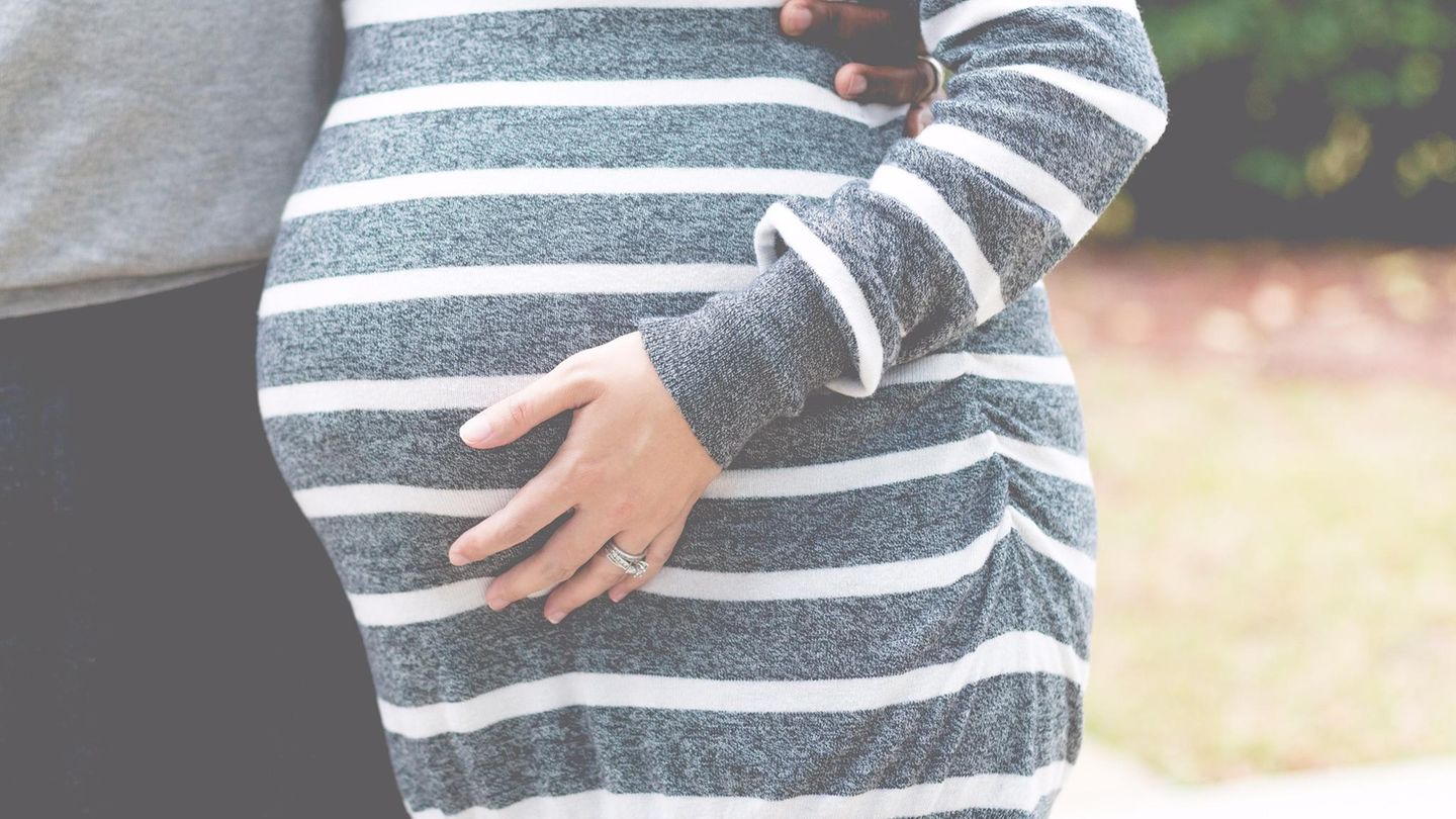Hochschwangere Frau hält die Hand an den Bauch