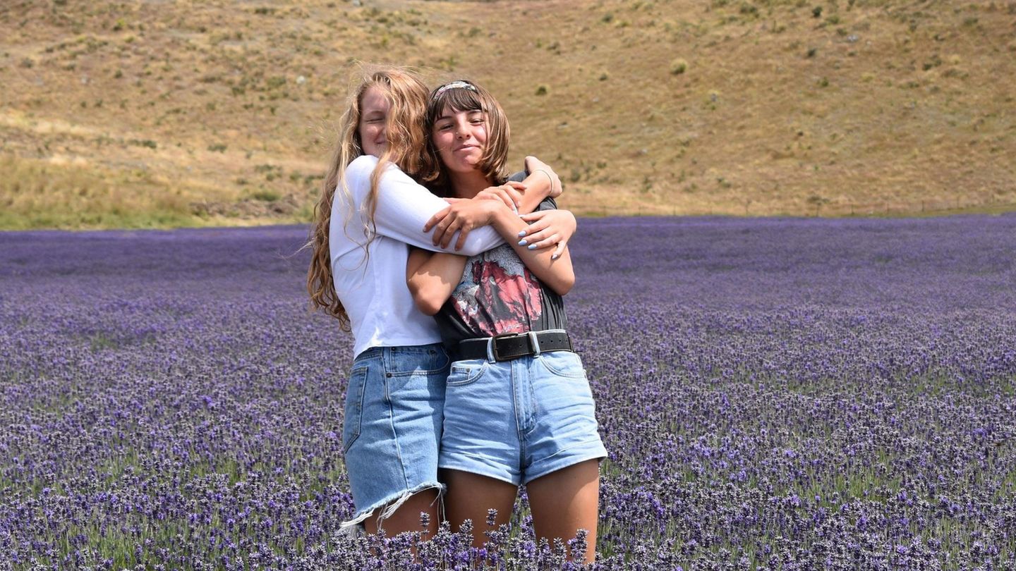 Zwei Mädchen Arm in Arm im Feld