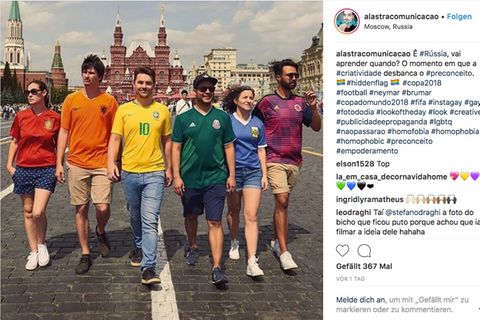 Sechs Brasilianer und Brasilianerinnen gehen in bunten Fußballtrikots über die Straße