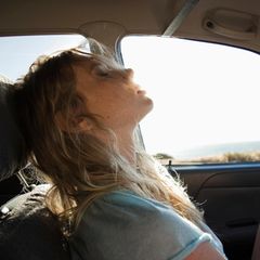 Eine junge Frau sitzt in einem Auto