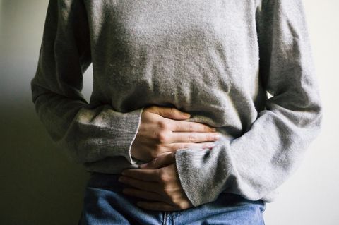 Eine Frau hält sich den Bauch