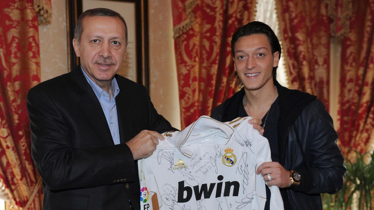 Links steht der türkische Präsident Recep Tayyip Erdogan, rechts Mesut Özil. Gemeinsam halten sie ein "Real Madrid"-Trikot