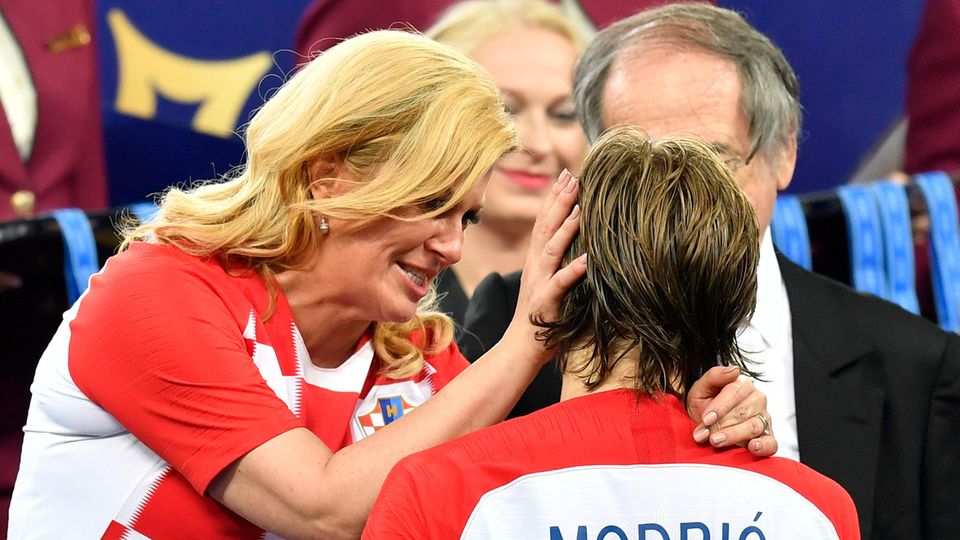 Kolinda Grabar-Kitarovic, die Präsidentin Kroatiens, steht im kroatischen Trikot da und tröstet Luca Modric