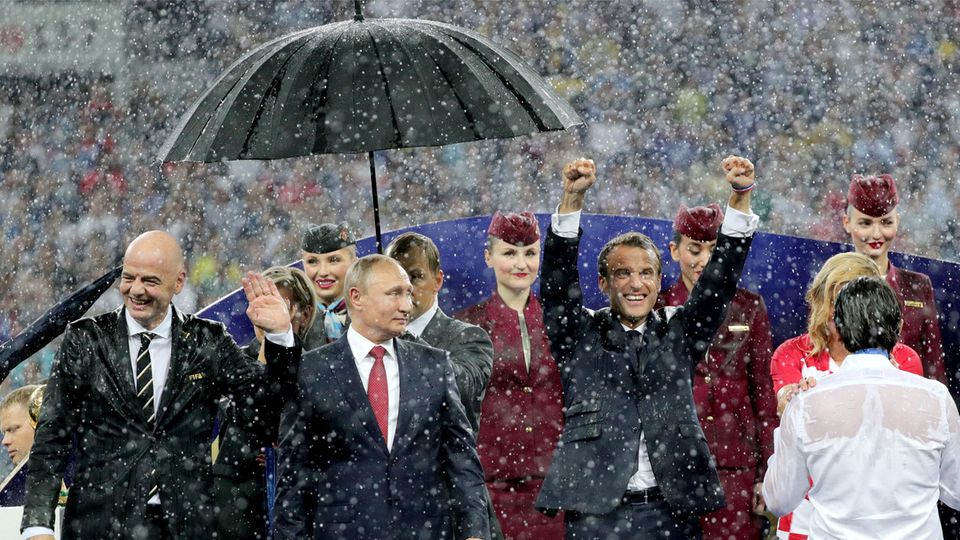 Der russische Präsident Wladimir Putin steht bei der WM-Siegerehrung im strömenden Regen als einziger unter einem Schirm