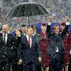 Der russische Präsident Wladimir Putin steht bei der WM-Siegerehrung im strömenden Regen als einziger unter einem Schirm