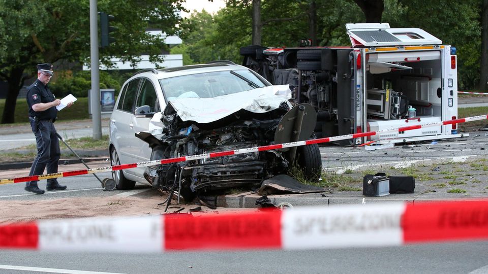 Unfall in Hamburg Nahe dem Hamburger Stadtpark liegt ein Rettungswagen nach einem Unfall mit einem weiteren Auto auf der Seite.