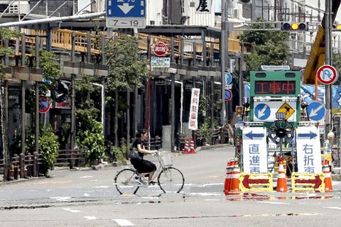 Eine Frau fährt mit dem Fahrrad durch Tokio, Japan