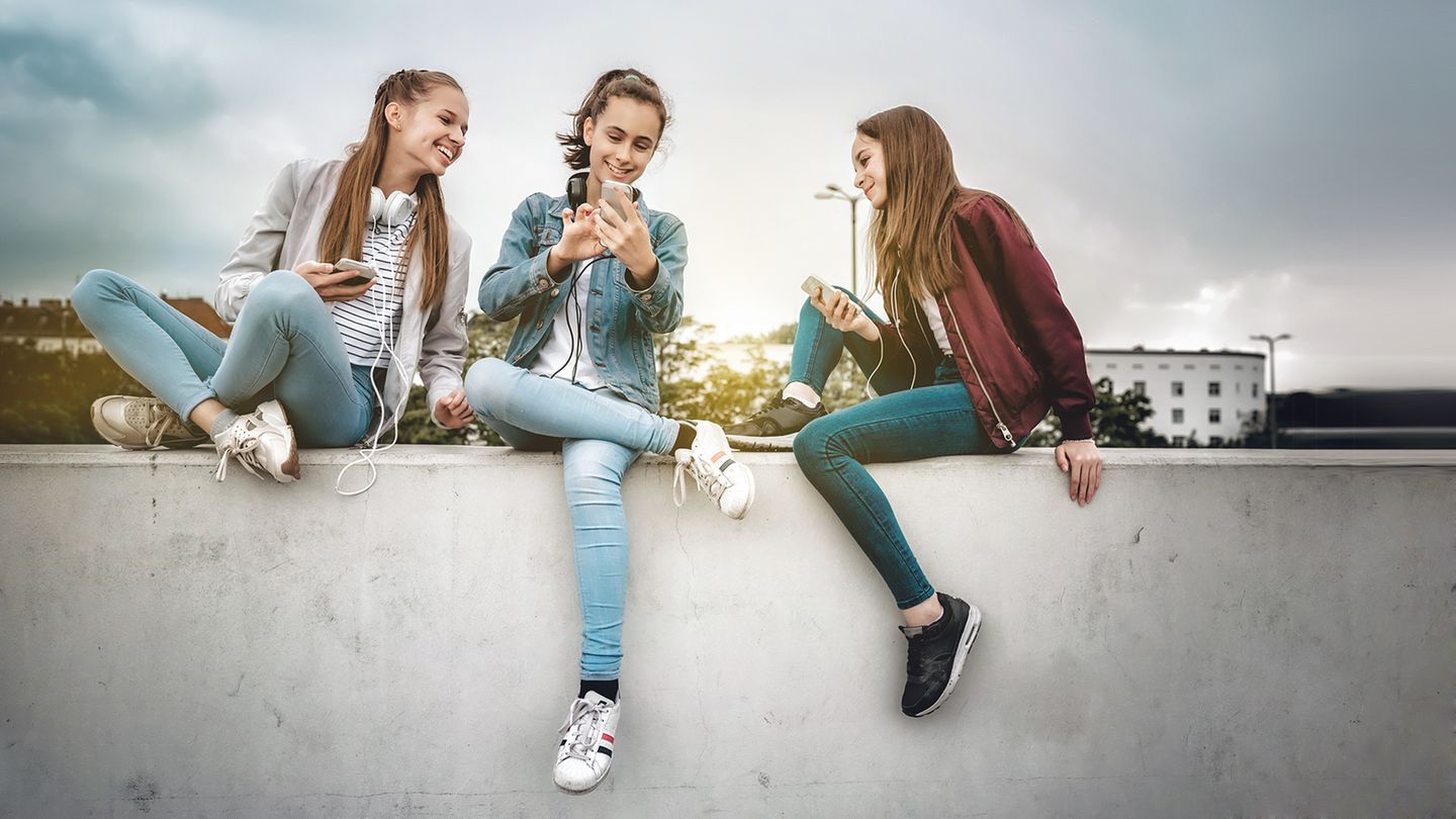 Drei Mädchen benutzen ihre Smartphones