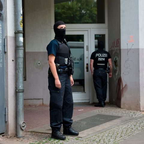 Im Rahmen einer Razzia durchsuchen Berliner Polizisten ein Gebäude