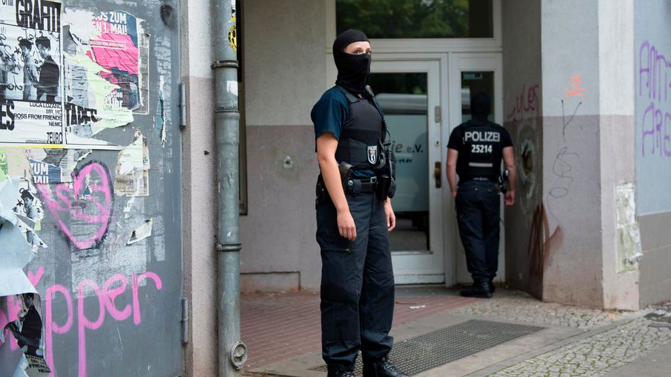 Im Rahmen einer Razzia durchsuchen Berliner Polizisten ein Gebäude