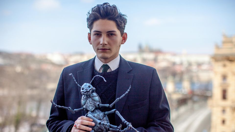 Virtual Reality: Kafka-Doppelgänger Marek Lentvorsky steht auf der Terrasse des Prager Goethe-Instituts und hält ein Modell des Insekts, in das sich Nutzer von VRwandlung verwandeln. Kafka-Doppelgänger Marek Lentvorsky steht auf der Terrasse des Prager Goethe-Instituts und hält ein Modell des Insekts, in das sich Nutzer von VRwandlung verwandeln.